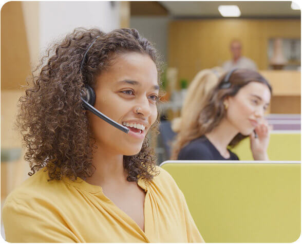 Woman in office talking with someone on a phone headset